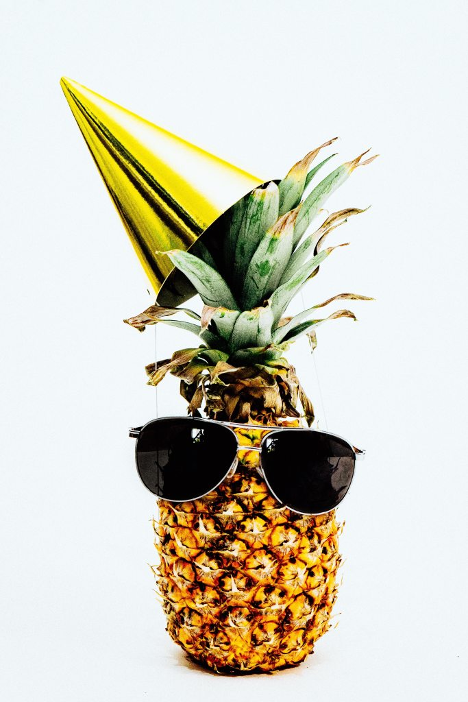 Pineapple wearing a hat and sunglasses